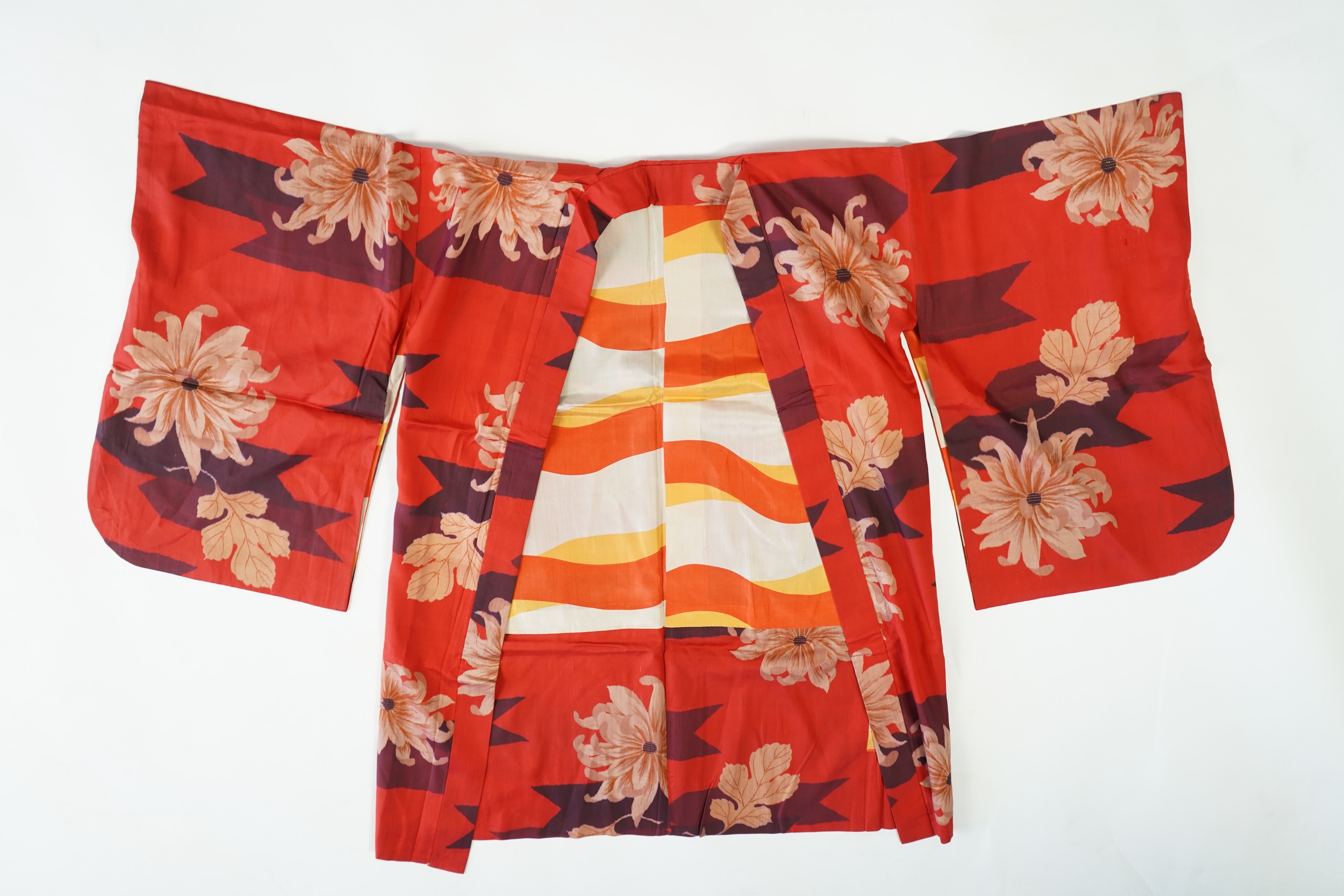 Three Japanese mid 20th century ‘Haori’ printed silk jackets. One red with brightly coloured lining and rust brown floral silk lining. All with large kimono sleeves. Grey patterned Haori, 79cm long., Condition - good